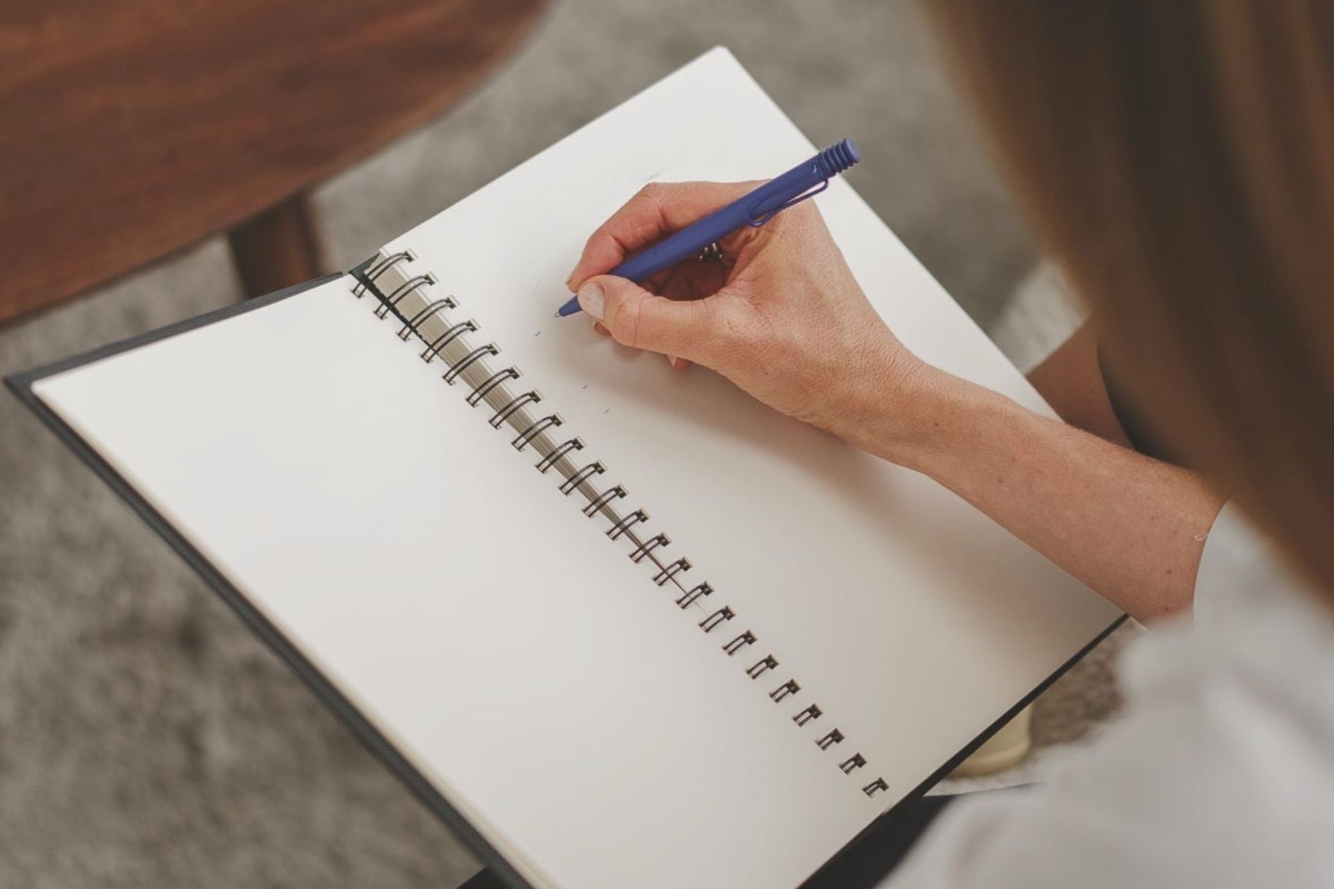 Hand von Verena Wölkhammer beim Schreiben in ein Notizbuch.